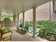 Relaxing outdoor porch with white pillars, seating area, and beautifully landscaped yard at 2616 Colton Dr, Charlotte, NC 28211