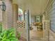 Inviting outdoor porch with brick pillars, lush greenery, and comfortable seating area at 2616 Colton Dr, Charlotte, NC 28211