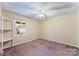 Bedroom featuring neutral walls, purple carpet, ceiling fan, and a built-in shelving unit at 2643 Providence Dr, Gastonia, NC 28052