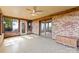Sunroom featuring brick walls, tile floor, a ceiling fan, and multiple doors and windows at 2643 Providence Dr, Gastonia, NC 28052