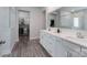 This is a modern bathroom with double sinks, white cabinets, and large mirror, with a walk in closet at 2890 Westshore Pl, Denver, NC 28037