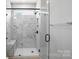 Modern bathroom featuring a glass enclosed shower with marble tile and a bench at 3214 Mcharney Dr # 34, Harrisburg, NC 28075