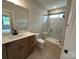 Modern bathroom featuring a wood vanity, stylish sink, and frameless glass shower with patterned tile at 3214 Mcharney Dr # 34, Harrisburg, NC 28075
