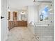 Bright bathroom featuring double sink vanity, soaking tub with glass shower and marble tile flooring at 3214 Mcharney Dr # 34, Harrisburg, NC 28075