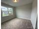 Clean bedroom with soft carpet, neutral walls, and a bright window overlooking the exterior view at 3214 Mcharney Dr # 34, Harrisburg, NC 28075