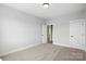 Spacious bedroom with neutral carpeting, an open doorway, and a white door at 3214 Mcharney Dr # 34, Harrisburg, NC 28075