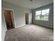 Bedroom with soft carpet, neutral walls, and a large window showing the exterior view at 3214 Mcharney Dr # 34, Harrisburg, NC 28075