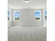 A bright, spacious bedroom has three windows and neutral carpet flooring at 3214 Mcharney Dr # 34, Harrisburg, NC 28075