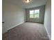 Cozy bedroom with plush carpet, neutral walls, and a bright window overlooking the exterior at 3214 Mcharney Dr # 34, Harrisburg, NC 28075