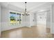 Bright dining room featuring a modern chandelier, natural light, and hardwood floors at 3214 Mcharney Dr # 34, Harrisburg, NC 28075