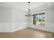 Sunlit dining room boasts board and batten trim, a chandelier, and large windows at 3214 Mcharney Dr # 34, Harrisburg, NC 28075