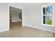 A light-filled empty room with a window and view, showcasing the light wood floors at 3214 Mcharney Dr # 34, Harrisburg, NC 28075