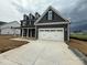 Stunning two-story home showcasing a modern exterior, a wide driveway, and a spacious two-car garage at 3214 Mcharney Dr # 34, Harrisburg, NC 28075