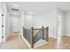 Hallway with wood railing, hardwood floors, and modern lighting at 3214 Mcharney Dr # 34, Harrisburg, NC 28075
