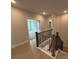 Upstairs hallway with wood-look floors, a dark-stained wood banister, and views into another room at 3214 Mcharney Dr # 34, Harrisburg, NC 28075