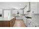 Open kitchen boasts an island, stainless steel appliances, white cabinets, and custom backsplash at 3214 Mcharney Dr # 34, Harrisburg, NC 28075