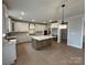 Bright kitchen featuring white cabinets, a central island, and modern pendant lighting at 3214 Mcharney Dr # 34, Harrisburg, NC 28075