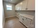 Bright laundry room with white shaker cabinets, white countertop, and luxury vinyl plank flooring at 3214 Mcharney Dr # 34, Harrisburg, NC 28075