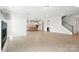 Spacious living room with hardwood floors connects to a modern kitchen and staircase at 3214 Mcharney Dr # 34, Harrisburg, NC 28075
