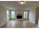 Bright living room with a modern fireplace, wood-look floors, and large windows offering natural light at 3214 Mcharney Dr # 34, Harrisburg, NC 28075