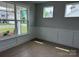 Bright living room with elegant wall paneling, light hardwood floors, and large windows at 3214 Mcharney Dr # 34, Harrisburg, NC 28075