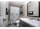 Cozy bathroom featuring a shower/tub combo with patterned curtain, storage cabinet and patterned mirror backsplash at 3678 Old Camden Hwy, Heath Springs, SC 29058