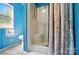 Simple bathroom with a white shower stall, blue walls, and a window for natural light at 3678 Old Camden Hwy, Heath Springs, SC 29058