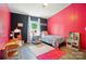Bedroom with a vibrant pink accent wall and bright natural light from the exterior coming through the window at 3678 Old Camden Hwy, Heath Springs, SC 29058