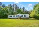 Inviting one-story home with lush green lawn and mature trees, accented by green shutters and a welcoming entrance at 3678 Old Camden Hwy, Heath Springs, SC 29058