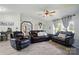 Bright living room with leather seating, ceiling fan, and large windows with sheer curtains at 3678 Old Camden Hwy, Heath Springs, SC 29058