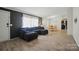 Living room with sleek laminate flooring and a plush blue sectional couch under bright natural light at 3678 Old Camden Hwy, Heath Springs, SC 29058
