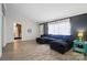 Cozy living room features a plush blue sectional couch, laminate floors, and natural light from the window at 3678 Old Camden Hwy, Heath Springs, SC 29058
