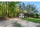 Exterior view of outbuilding with double doors, nestled among tall trees, offering versatile storage or hobby space at 3678 Old Camden Hwy, Heath Springs, SC 29058