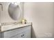 Bathroom vanity features granite countertops, white cabinetry, and a decorative oval mirror at 3722 Windy Pine Nw Ln, Hickory, NC 28601