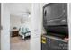 A black stackable washer/dryer sits beside a bedroom featuring carpet floors and a ceiling fan at 3722 Windy Pine Nw Ln, Hickory, NC 28601