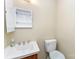 A bathroom features a sink with a medicine cabinet and a toilet with a white lid at 3941 Briarhill Dr, Charlotte, NC 28215