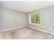 Bedroom with neutral walls, carpet, and window overlooking green space, offering a serene and comfortable environment at 3941 Briarhill Dr, Charlotte, NC 28215
