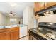 A bright kitchen includes a stove, sink, dishwasher, and a view into an adjacent room with a ceiling fan at 3941 Briarhill Dr, Charlotte, NC 28215