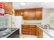Functional kitchen with wood cabinetry, white appliances, and tile flooring provides ample storage and workspace at 3941 Briarhill Dr, Charlotte, NC 28215