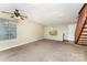 Bright living room with a fan, large windows, neutral walls and staircase at 3941 Briarhill Dr, Charlotte, NC 28215
