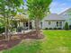Spacious backyard with a covered patio, lush lawn, and mature landscaping, ideal for outdoor living and entertaining at 423 Sensibility Cir, Fort Mill, SC 29708