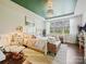 Spacious bedroom with green accent ceiling, chandelier, and sitting area at 423 Sensibility Cir, Fort Mill, SC 29708