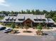 Exterior of the community clubhouse, featuring a stone facade, a covered entrance, and ample parking at 423 Sensibility Cir, Fort Mill, SC 29708