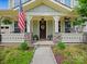Inviting front porch with decorative columns, stone accents, a welcome mat, and an American flag display at 423 Sensibility Cir, Fort Mill, SC 29708
