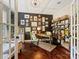 Cozy home office with dark accent wall, custom shelving, hardwood floors, and French doors at 423 Sensibility Cir, Fort Mill, SC 29708