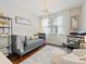 Bright office features a gray sofa, chandelier, desk, and white chair at 423 Sensibility Cir, Fort Mill, SC 29708
