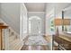 Bright foyer featuring hardwood floors, a staircase, and an arched doorway at 4525 Island Waters Dr, Denver, NC 28037