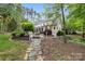 Charming yellow home with a landscaped yard, stone pathway, and inviting front porch at 4525 Island Waters Dr, Denver, NC 28037
