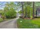 A long driveway to a beautiful home surrounded by lush greenery and mature trees at 4525 Island Waters Dr, Denver, NC 28037