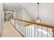 Upstairs hallway featuring a built-in bookshelf and railing overlooking the home's entry at 4525 Island Waters Dr, Denver, NC 28037